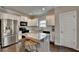 Modern kitchen with stainless steel appliances, granite counters, island with seating and wood floors at 6468 Pierless Ave, Sugar Hill, GA 30518