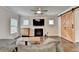Comfortable living room featuring a fireplace, TV, barn door, hardwood floors, and a neutral color scheme at 6468 Pierless Ave, Sugar Hill, GA 30518