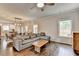 Open-concept living room with hardwood floors, comfortable sofa, and a view into the kitchen and dining area at 6468 Pierless Ave, Sugar Hill, GA 30518
