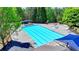 Aerial view of a large swimming pool with lounge chairs and umbrellas, surrounded by lush greenery at 6468 Pierless Ave, Sugar Hill, GA 30518