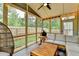 Relaxing screened-in porch featuring comfortable seating, a ceiling fan, string lights, and views of the backyard at 6468 Pierless Ave, Sugar Hill, GA 30518
