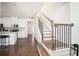Bright entryway with hardwood floors, a staircase with black iron railings, and an open kitchen area at 875 Venture Sw Way, Atlanta, GA 30331