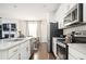 Modern kitchen with white countertops, stainless steel appliances, and a view into the living area at 875 Venture Sw Way, Atlanta, GA 30331