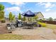 Backyard featuring a brick patio with a table and chairs, landscaped bushes and trees, and a grill at 170 Oakleigh Manor Dr, Fayetteville, GA 30215
