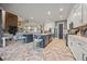 Open-concept kitchen with large island, stainless appliances, and herringbone-patterned floors flows to living area at 170 Oakleigh Manor Dr, Fayetteville, GA 30215