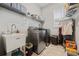 Functional laundry room with utility sink, shelving, and modern washer and dryer at 170 Oakleigh Manor Dr, Fayetteville, GA 30215