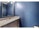 Half bathroom with vanity, stone countertop, gold faucet and a navy blue painted wall at 220 Semel Cir # 150, Atlanta, GA 30309