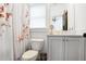This bathroom is brightly lit and features a vanity and sink, mirror, floral shower curtain, and toilet at 3272 Stillwood Dr, Atlanta, GA 30354