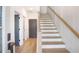 Bright entryway featuring wood staircase, modern lighting, and stylish doors, with hardwood flooring at 3272 Stillwood Dr, Atlanta, GA 30354