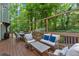 Spacious wooden back deck with comfortable seating, table, and overhead string lights in a wooded setting at 4853 Ridgewood Creek Nw Dr, Acworth, GA 30102