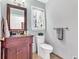 Cozy bathroom with single sink vanity, mirror, toilet, towel rack, and a window for natural light at 4853 Ridgewood Creek Nw Dr, Acworth, GA 30102