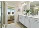 A double vanity bathroom that looks into a spacious bedroom with ample natural light at 518 Provence Gate Ln, Lawrenceville, GA 30044