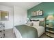 Cozy bedroom featuring a green accent wall, bedside tables and plush bedding at 518 Provence Gate Ln, Lawrenceville, GA 30044