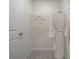 A closet with a white robe hanging from the top shelf at 518 Provence Gate Ln, Lawrenceville, GA 30044