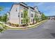 A wide view showcasing multiple townhomes along a tree-lined street with well-maintained landscaping at 2669 Caruso Way, Atlanta, GA 30339