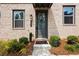 Close-up of a front door with brick surround and manicured landscaping at 2669 Caruso Way, Atlanta, GA 30339
