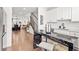 Open-concept kitchen features a black marble island, white cabinets, and views of the living and dining areas at 2669 Caruso Way, Atlanta, GA 30339