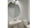 Bathroom featuring a round mirror, sink with pedestal and a toilet at 4534 Eastbrook Pl, Snellville, GA 30039