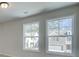 A well-lit bedroom featuring two large windows and neutral walls and carpeting at 4534 Eastbrook Pl, Snellville, GA 30039