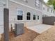 Rear exterior featuring neutral siding, white brick foundation, and a gravel landscape design at 4659 Larkfield Way, Powder Springs, GA 30127