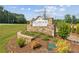Stone community sign with landscaping and mature trees on a sunny day at 4659 Larkfield Way, Powder Springs, GA 30127