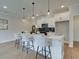 Bright, modern kitchen features pendant lighting, stainless appliances and sleek white cabinetry at 4659 Larkfield Way, Powder Springs, GA 30127