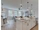 Open concept kitchen with stainless appliances, white cabinets, quartz countertops, and adjacent living area at 4659 Larkfield Way, Powder Springs, GA 30127