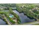 Aerial view of a community lake, pool, tennis courts, and surrounding trees at 7979 Larksview Dr, Fairburn, GA 30213