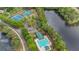 Aerial view of a community swimming pool, tennis courts, and green spaces surrounded by lush trees and homes at 7979 Larksview Dr, Fairburn, GA 30213