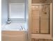 Bathroom featuring large tub and shower stall at 7979 Larksview Dr, Fairburn, GA 30213