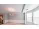 Elegant dining room with a tray ceiling, large windows, decorative wainscoting, and a chandelier at 7979 Larksview Dr, Fairburn, GA 30213