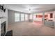 Bright living room featuring large windows, fireplace, and open access to the kitchen area at 7979 Larksview Dr, Fairburn, GA 30213