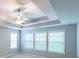 Main bedroom featuring tray ceilings, neutral color palette, carpet flooring and several large windows at 7979 Larksview Dr, Fairburn, GA 30213