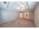 Spacious carpeted main bedroom with tray ceiling and ceiling fan at 7979 Larksview Dr, Fairburn, GA 30213