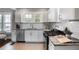 Bright kitchen featuring white cabinets, stainless appliances, granite countertops, and tile backsplash at 949 Hope Sw Dr, Atlanta, GA 30310
