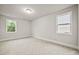 Empty bedroom with neutral walls and carpet, featuring two windows offering natural light at 125 Registry Ln, Canton, GA 30115