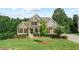 Beautiful home with manicured lawn, stone facade, dormer windows, and inviting entryway at 125 Registry Ln, Canton, GA 30115