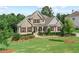 Charming two-story home with a stone facade, manicured lawn, and mature trees at 125 Registry Ln, Canton, GA 30115