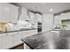 Modern kitchen featuring white cabinetry, stainless steel appliances, and sleek dark countertops at 125 Registry Ln, Canton, GA 30115