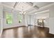 Bright, open-concept living room with coffered ceiling, hardwood floors, and wainscoting at 125 Registry Ln, Canton, GA 30115