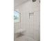 Modern shower featuring tiled walls, a corner seat, a built-in niche, and seamless glass at 125 Registry Ln, Canton, GA 30115