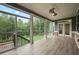 Relaxing sunroom features wood-look flooring, ceiling fan, and lots of natural light at 125 Registry Ln, Canton, GA 30115