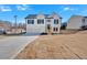 Charming two-story home with white siding, black shutters, and a two-car garage against a clear blue sky at 19 Bridgemill Dr, Douglasville, GA 30134