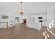Spacious kitchen with white cabinets, a central island, and an adjacent living area featuring a fireplace at 19 Bridgemill Dr, Douglasville, GA 30134