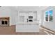 Modern kitchen with white cabinets, island seating, stainless appliances, and a stone fireplace nearby at 19 Bridgemill Dr, Douglasville, GA 30134