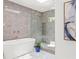Bright bathroom features a freestanding tub, glass enclosed shower, and marble floors at 228 Mount Vernon Dr, Decatur, GA 30030