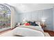 A primary bedroom with light blue paneled walls and a beautiful stained glass window at 228 Mount Vernon Dr, Decatur, GA 30030