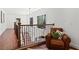 This hallway features hardwood floors, black iron railings, and a comfy armchair with throw pillows at 228 Mount Vernon Dr, Decatur, GA 30030