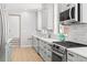 Modern kitchen featuring gray cabinets, a marble backsplash, and stainless steel appliances, with hardwood floors at 228 Mount Vernon Dr, Decatur, GA 30030
