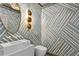 Modern powder room with unique geometric wallpaper, oval mirror, and stylish lighting at 228 Mount Vernon Dr, Decatur, GA 30030